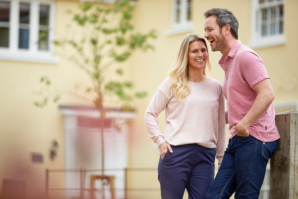 A couple laughing outside of their Hopkins home