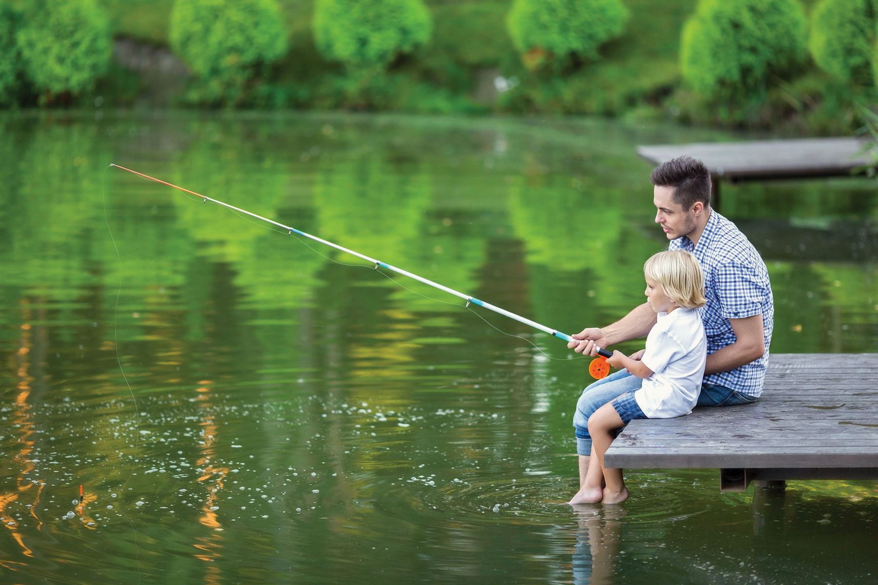 Father And Son Fising On A Lake