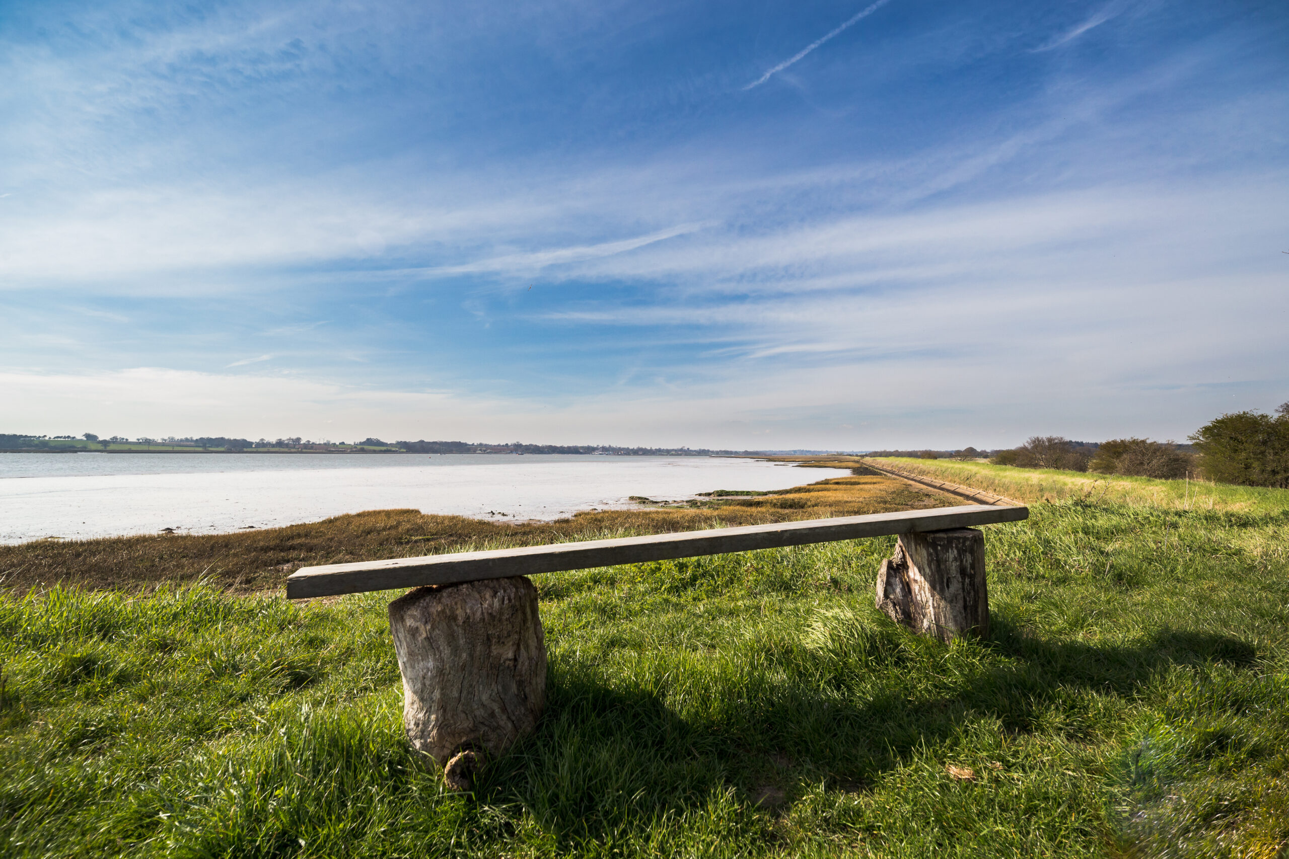 Stone and wooden bench by the Suffolk coastline