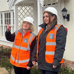Two people on site with hi vis and hard hats