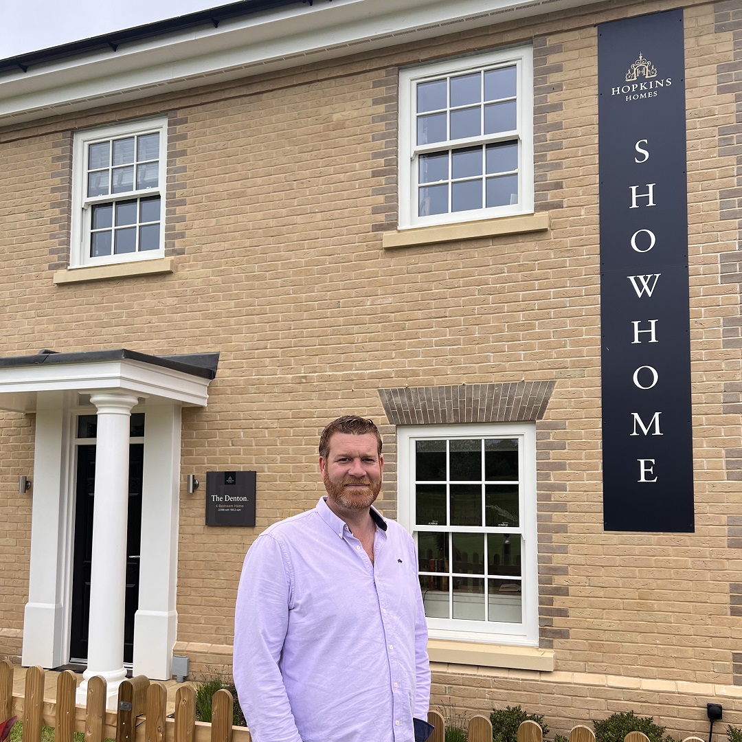 Man standing in front of home showhome