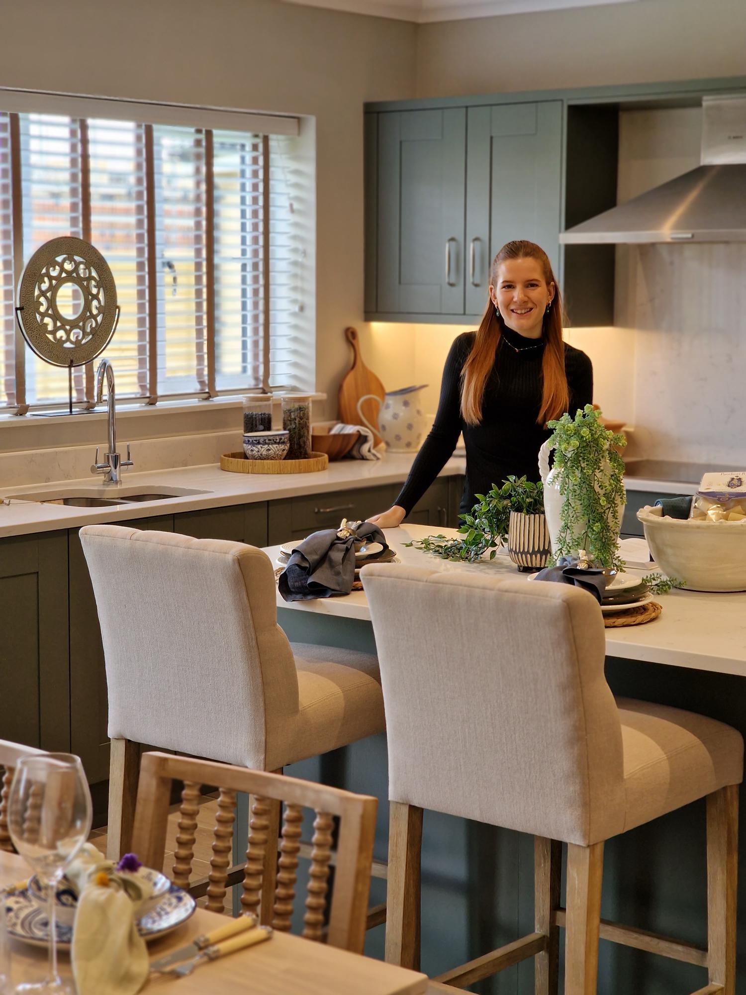 Woman standing in kitchen leaning on kitchen island