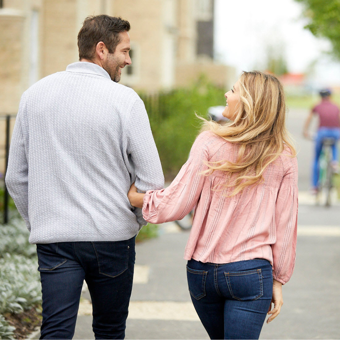 Couple walking arm in arms through a Hopkins Homes development