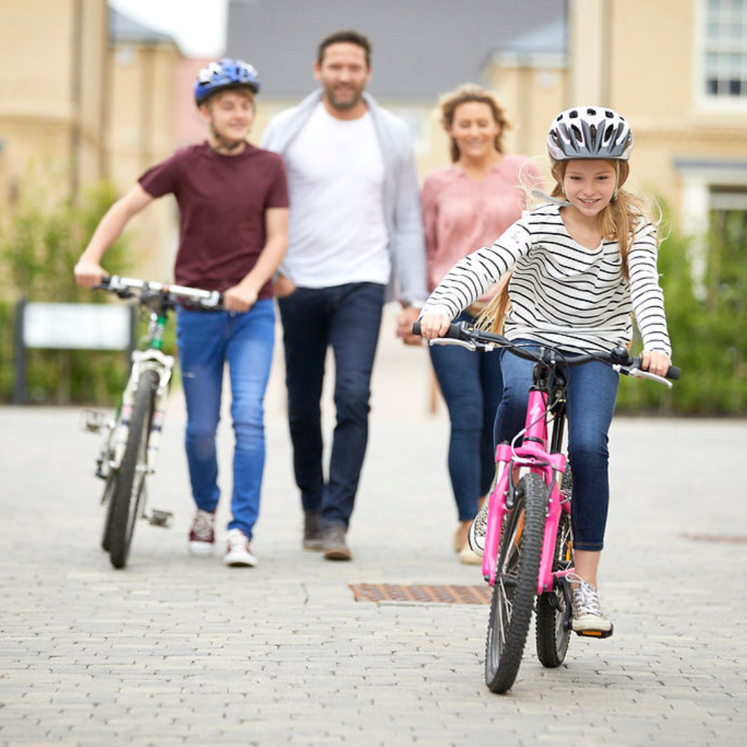 A family of 4 with the children on bikes